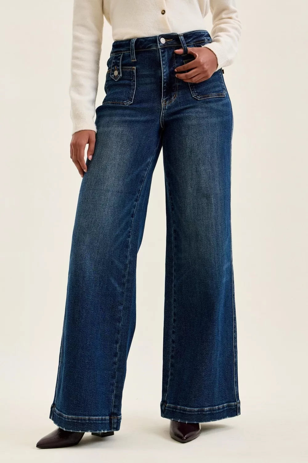 Person wearing blue wide-leg jeans on a plain background