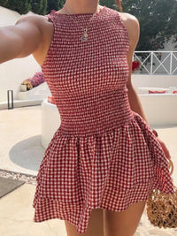 Person wearing a red and white checkered dress outdoors.
