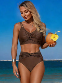 Woman in a brown bikini holding a coconut drink with a straw and flower on a beach.