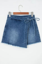Blue denim skirt on a hanger against a white background