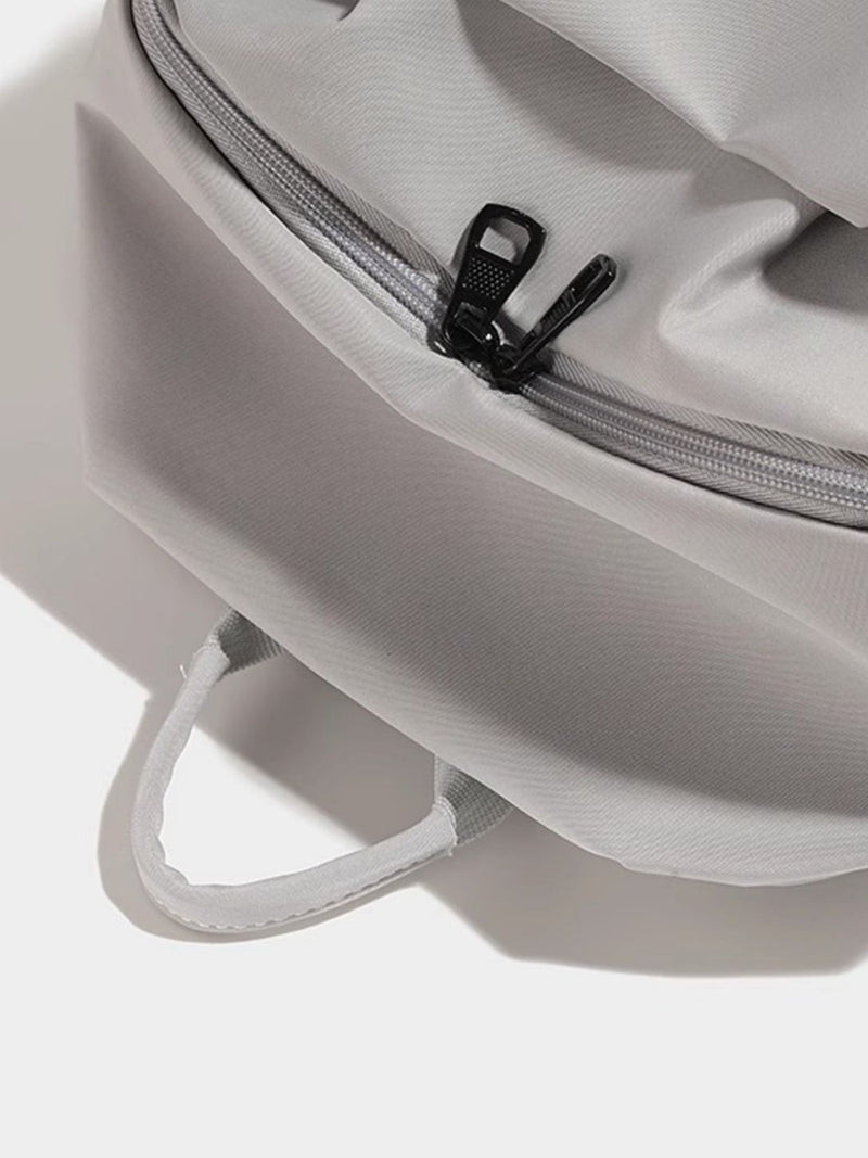 Close-up of a gray backpack with a zipper on a white background