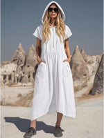 Woman wearing a white hooded dress with rock formations in the background