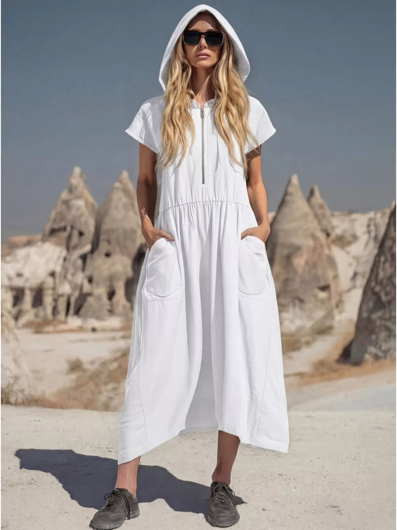 Woman wearing a white hooded dress with rock formations in the background