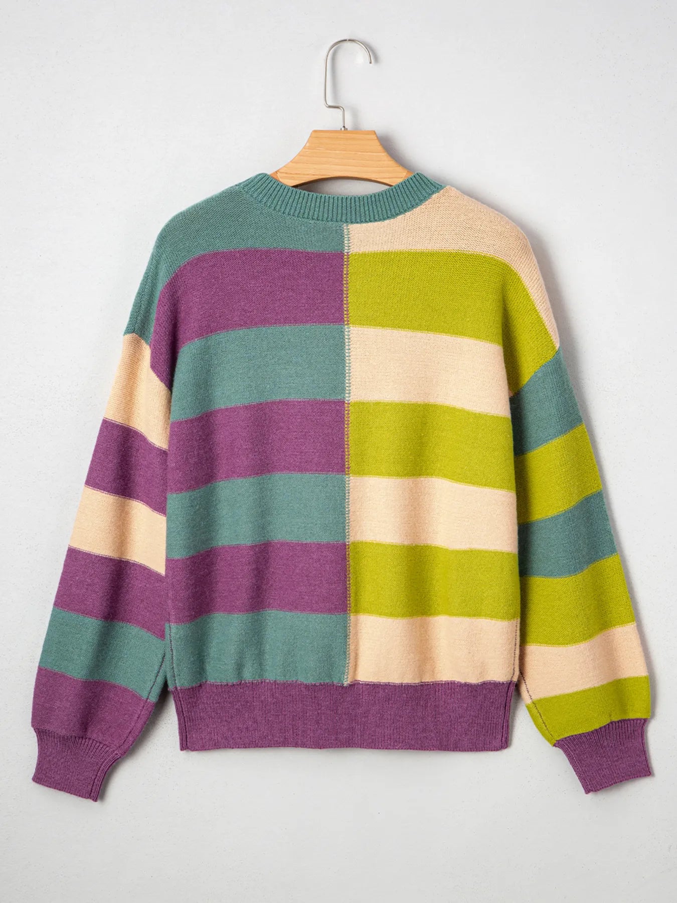 Colorful striped sweater on a hanger against a white background