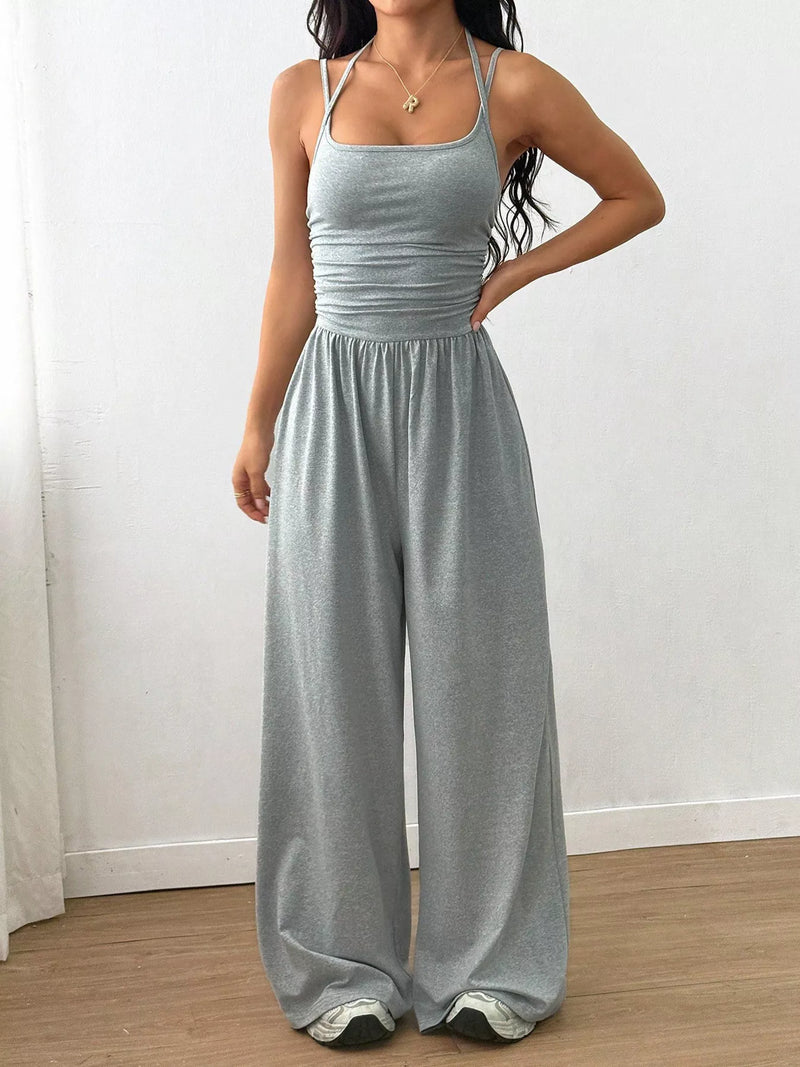 Woman wearing a gray jumpsuit against a white background