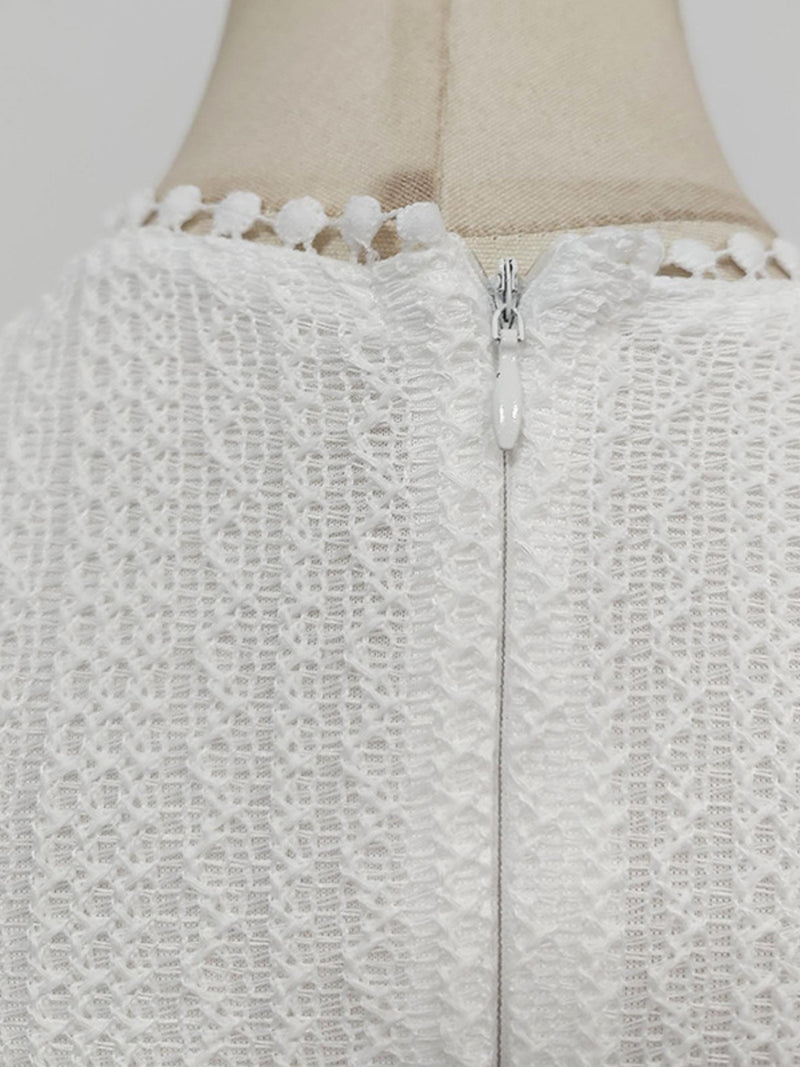 Close-up of a textured white garment with a zipper on a mannequin.