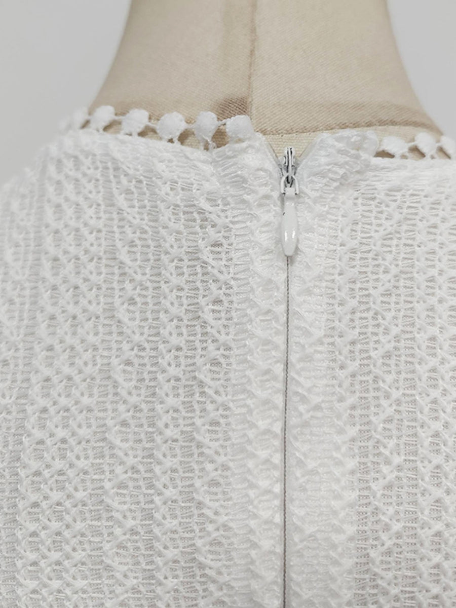 Close-up of a textured white garment with a zipper on a mannequin.