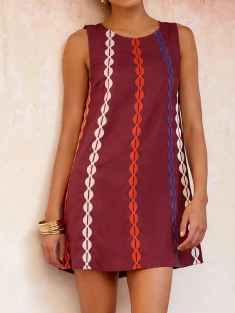 Maroon dress with colorful geometric pattern worn by a person against a light background