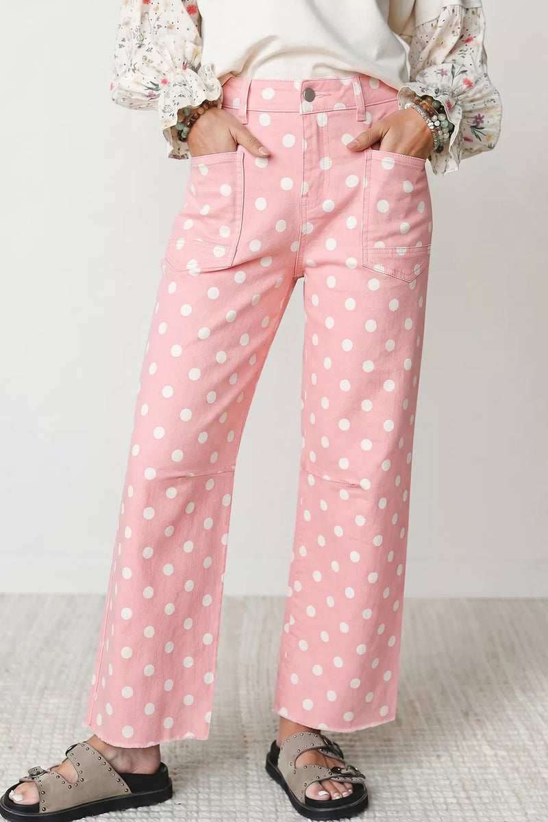 Pink wide-leg cropped pants with a white polka dot pattern, shown on a model wearing a cream top and brown slide sandals.