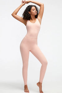 Woman wearing a light pink bodysuit against a white background