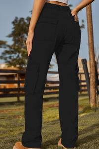 Person wearing black cargo pants with a blurred outdoor background