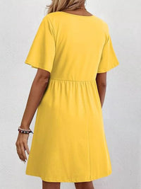 Yellow dress worn by a person on a plain background