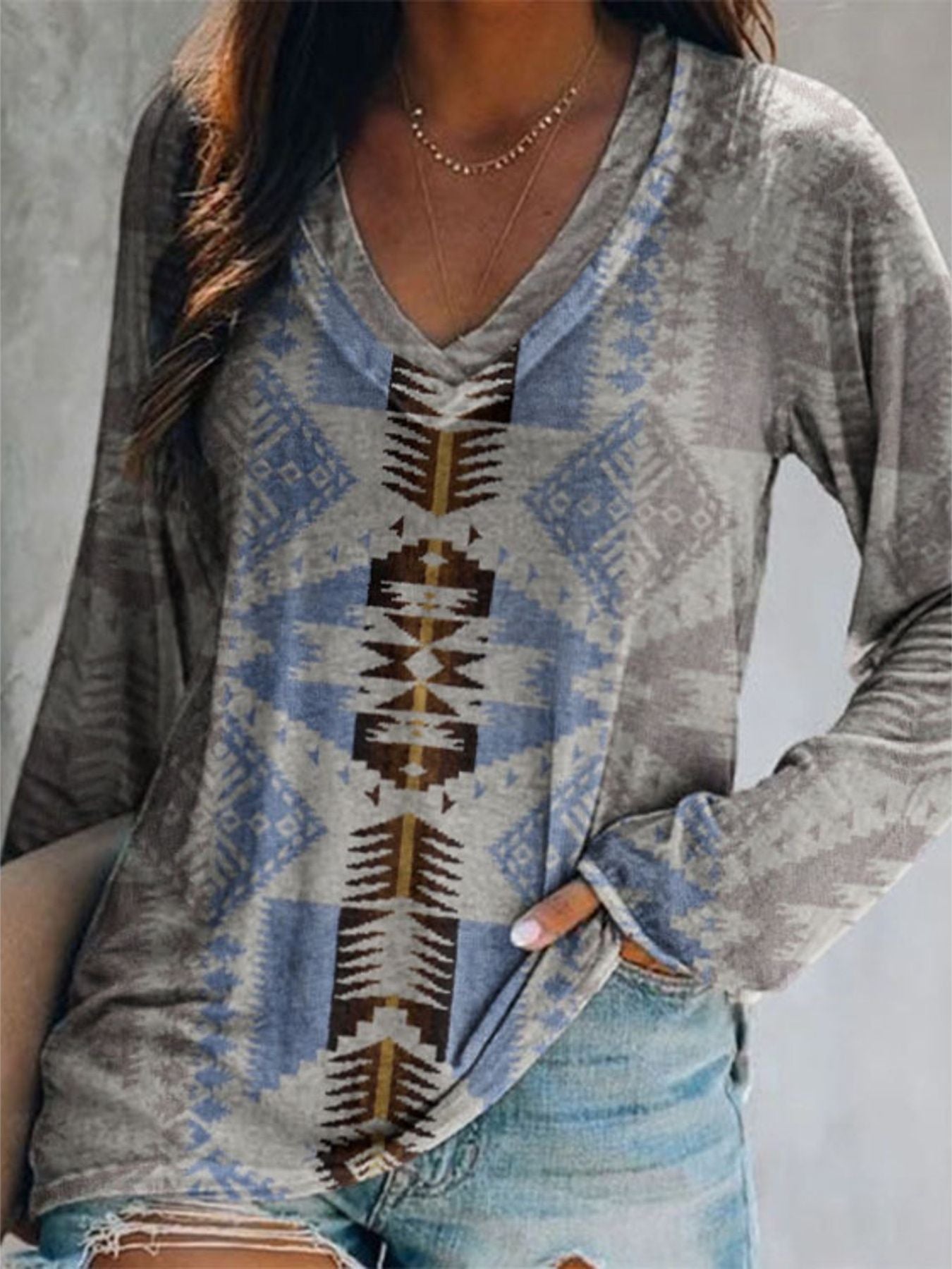 Person wearing a patterned long-sleeve shirt with a neutral background