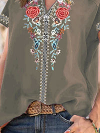 Green sleeveless top with floral embroidery and a leopard print belt.