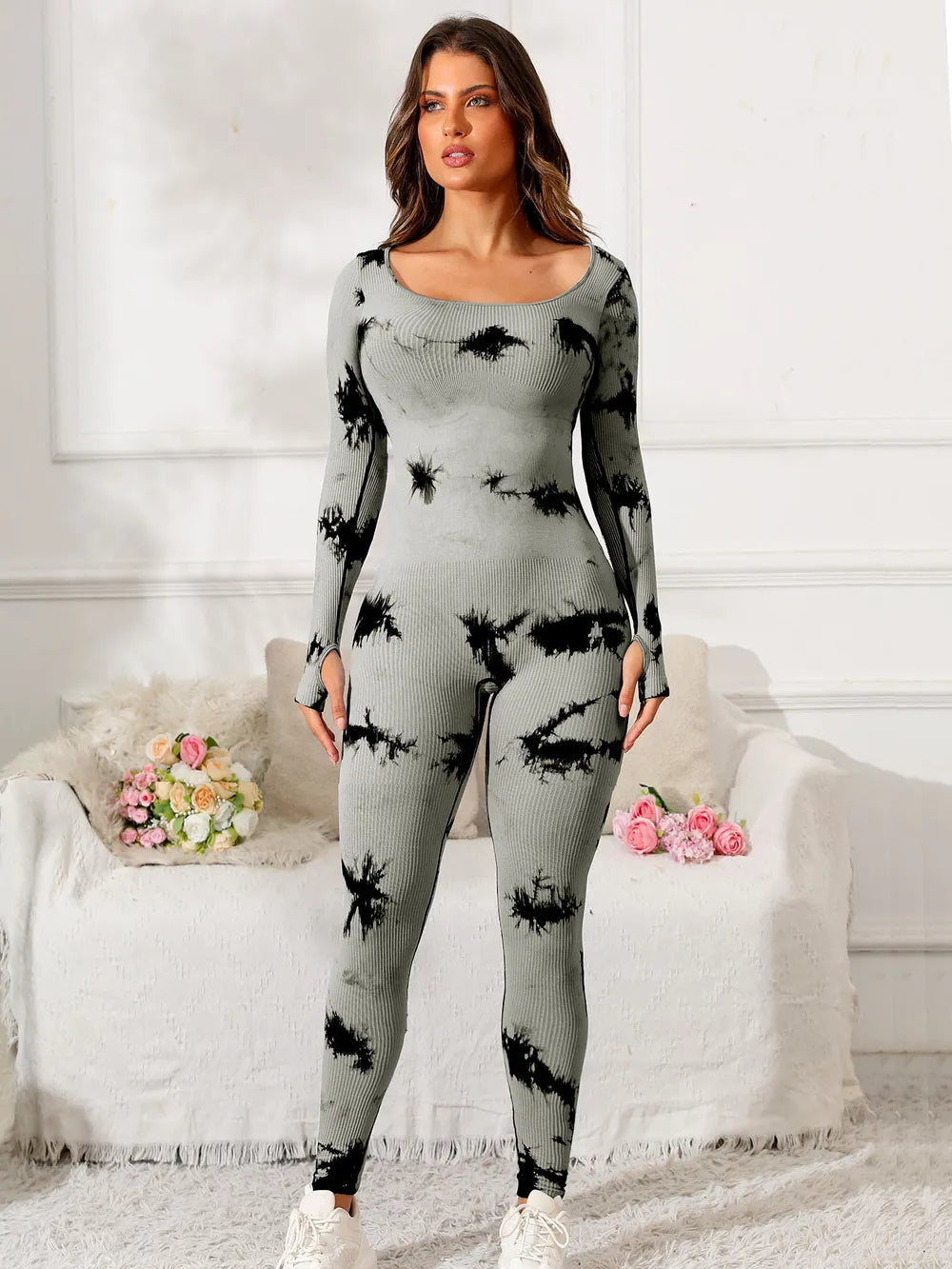 Woman wearing a gray and black tie-dye outfit in a living room setting.