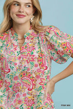 Woman wearing a colorful floral dress against a light blue background