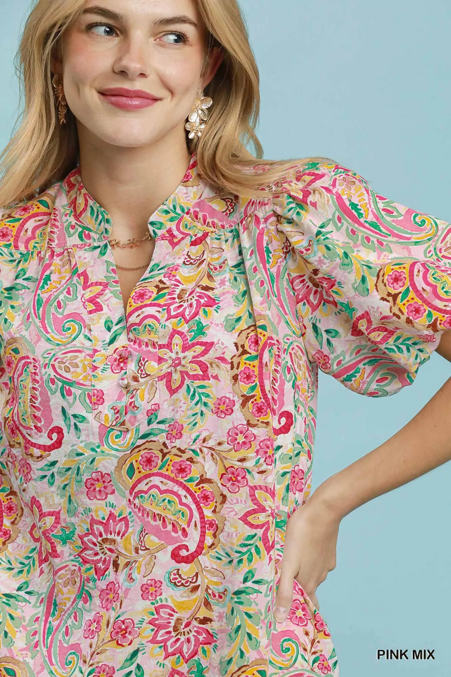 Woman wearing a colorful floral dress against a light blue background