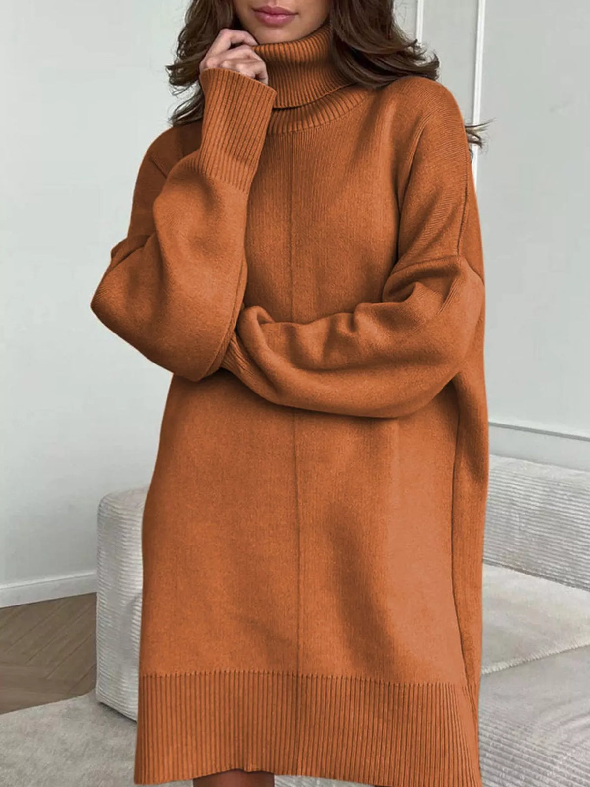 Person wearing a brown sweater dress in an indoor setting