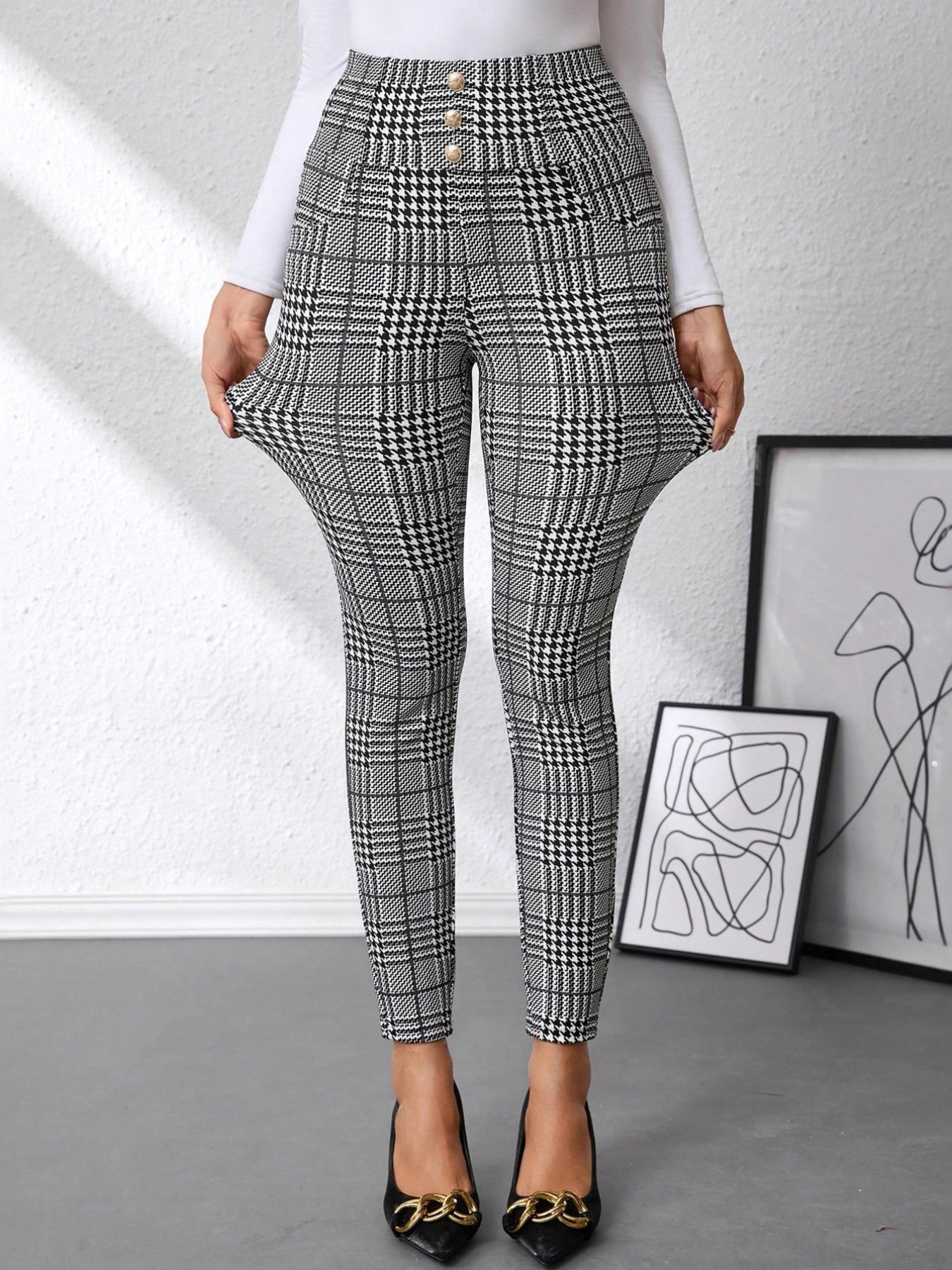 Plaid pants worn by a person with abstract art in the background