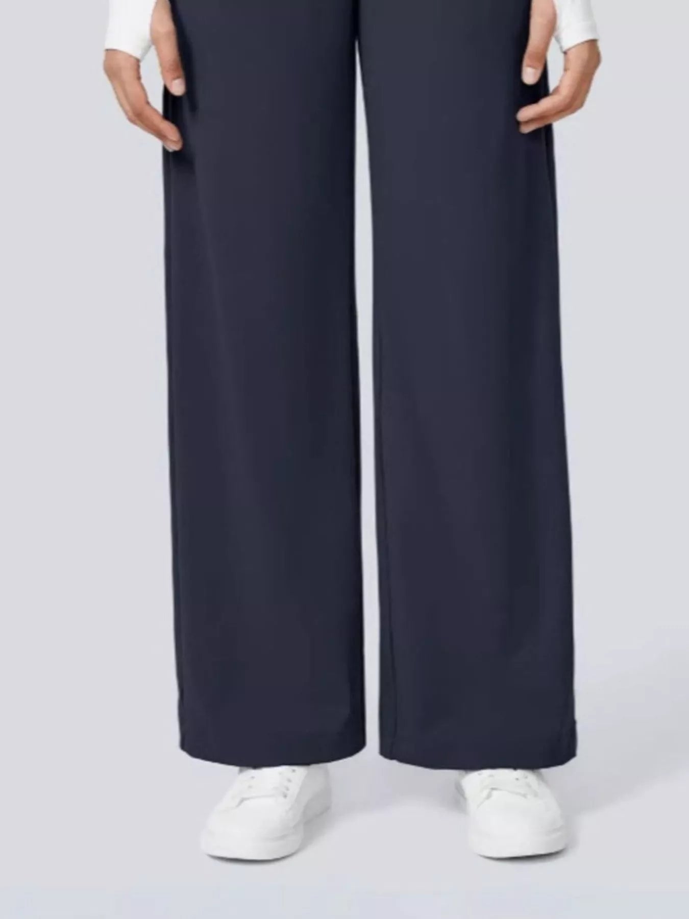 Navy wide-leg pants worn by a person on a light gray background