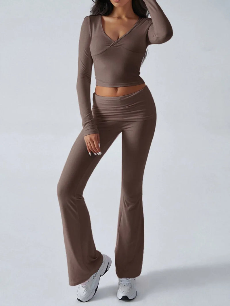Woman wearing a brown long-sleeve top and flared pants on a white background