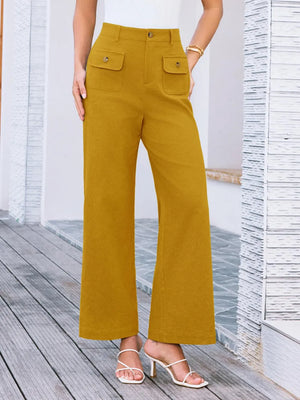 Mustard yellow pants worn by a person on a wooden deck.