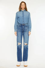 Woman wearing a denim shirt and jeans on a white background