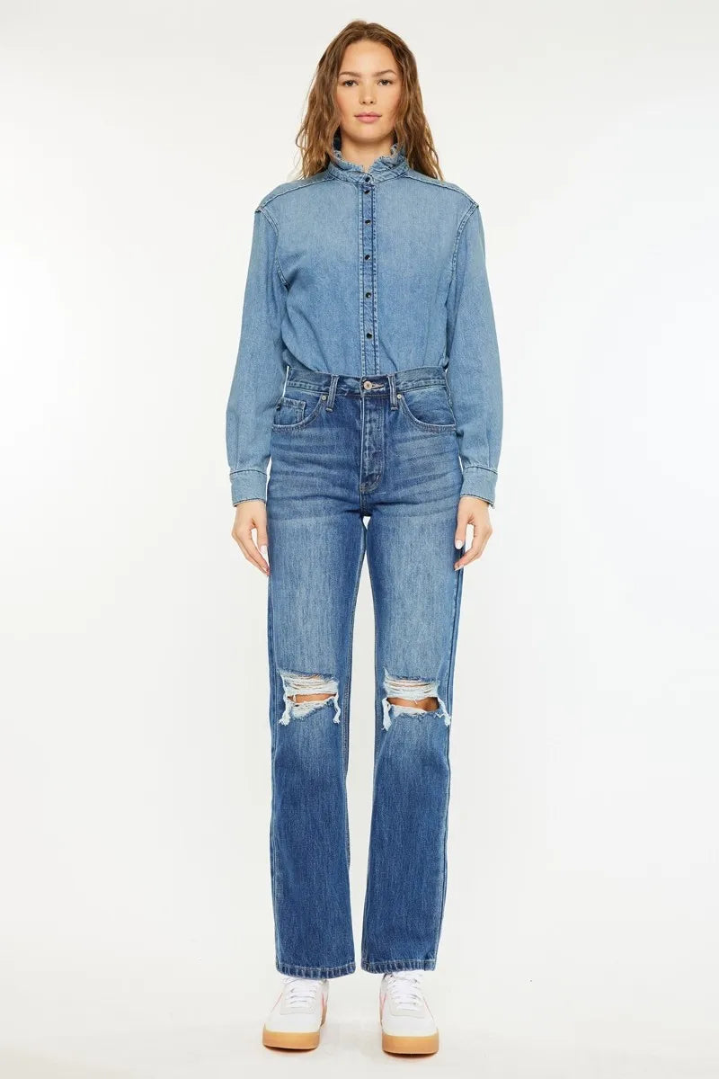 Woman wearing a denim shirt and jeans on a white background
