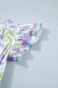 Floral-patterned fabric with purple and green colors on a light gray background