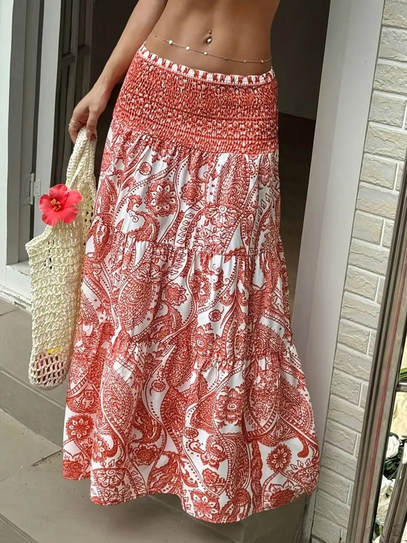 Person wearing a red and white patterned skirt holding a straw bag with a pink flower.