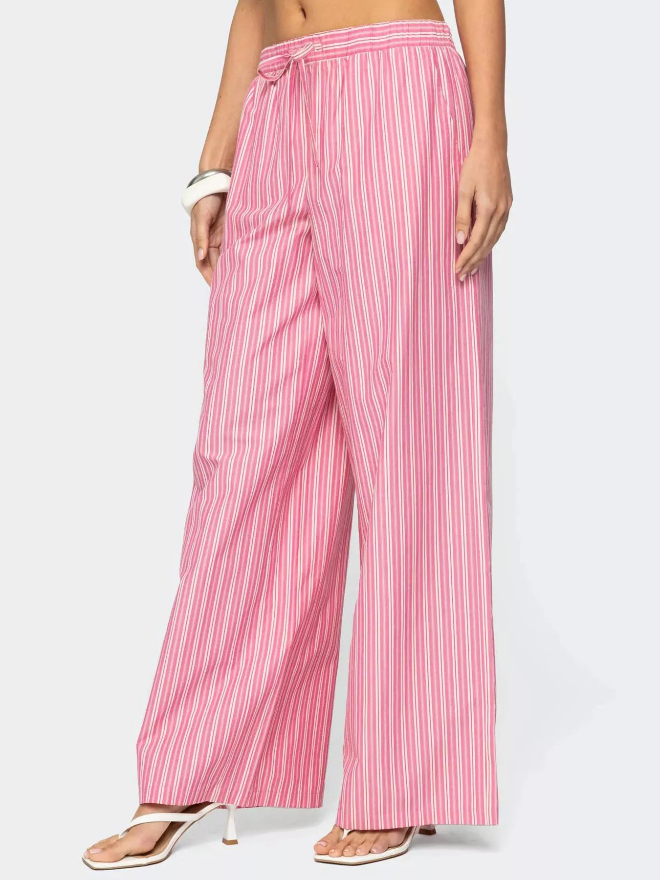 Pink striped pants worn by a person on a white background