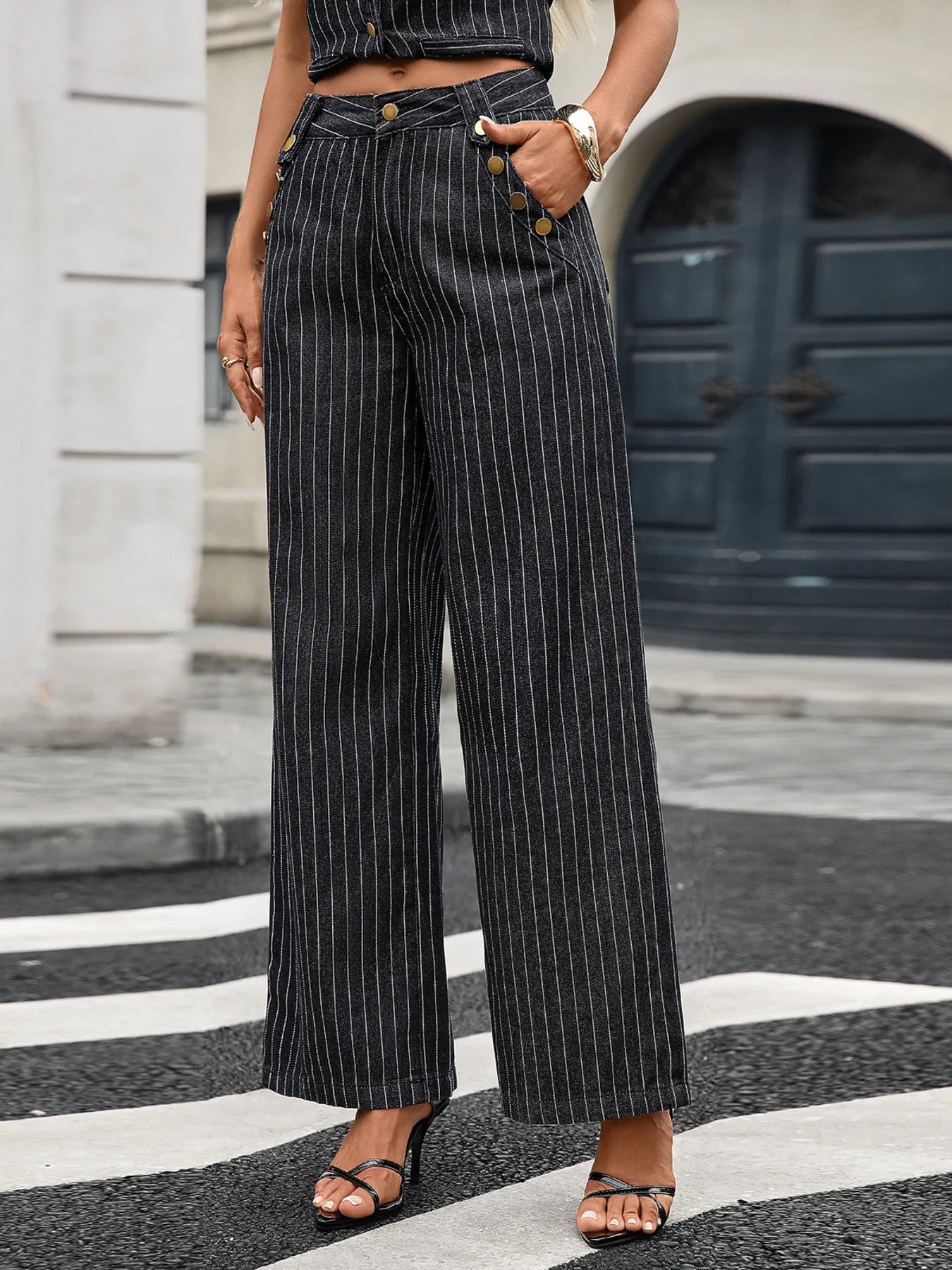 Person wearing pinstripe pants standing on a zebra crossing.