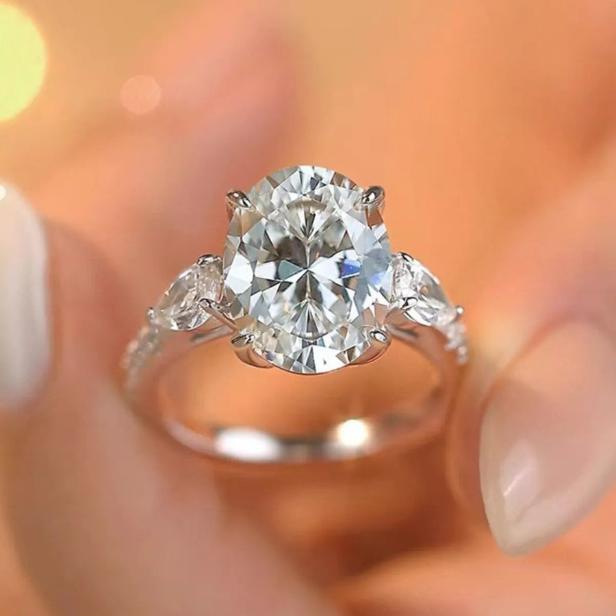 Diamond ring held by a hand with a blurred background