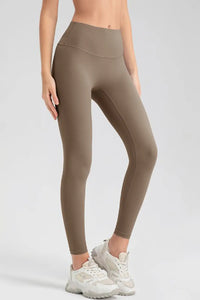 Person wearing olive green leggings on a white background