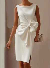 White dress with a large bow detail on a plain background