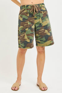 Camouflage shorts worn by a person on a white background