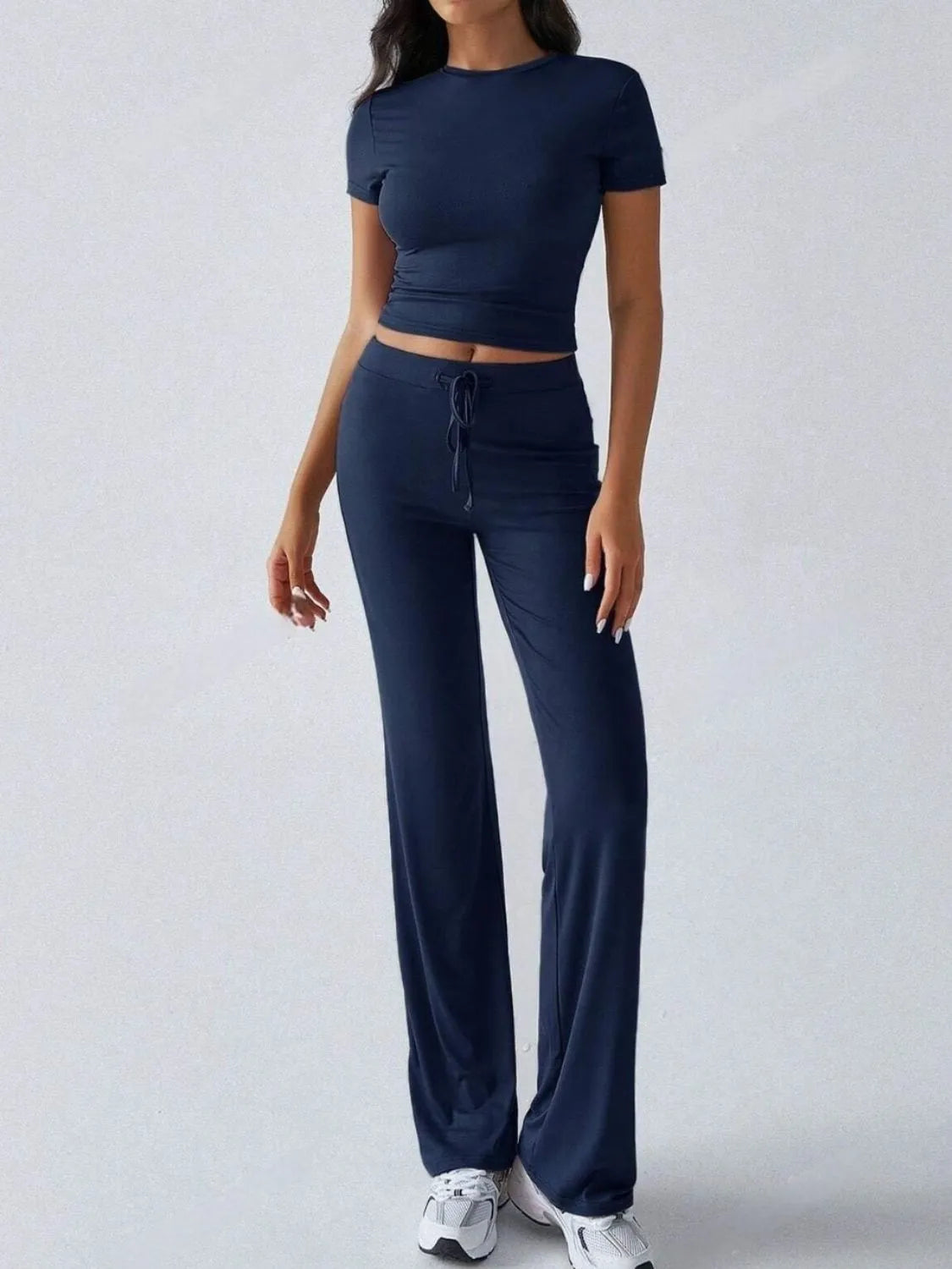 Person wearing a navy blue athletic outfit on a light gray background