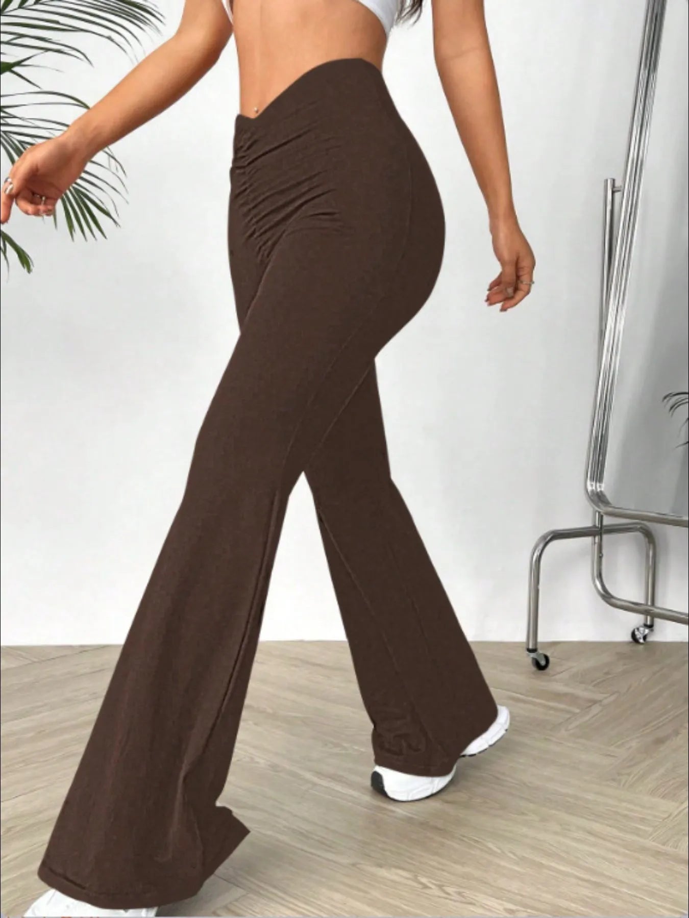 Brown wide-leg pants worn by a person on a light wooden floor.