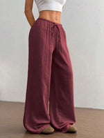 Maroon wide-leg pants worn by a person on a plain background