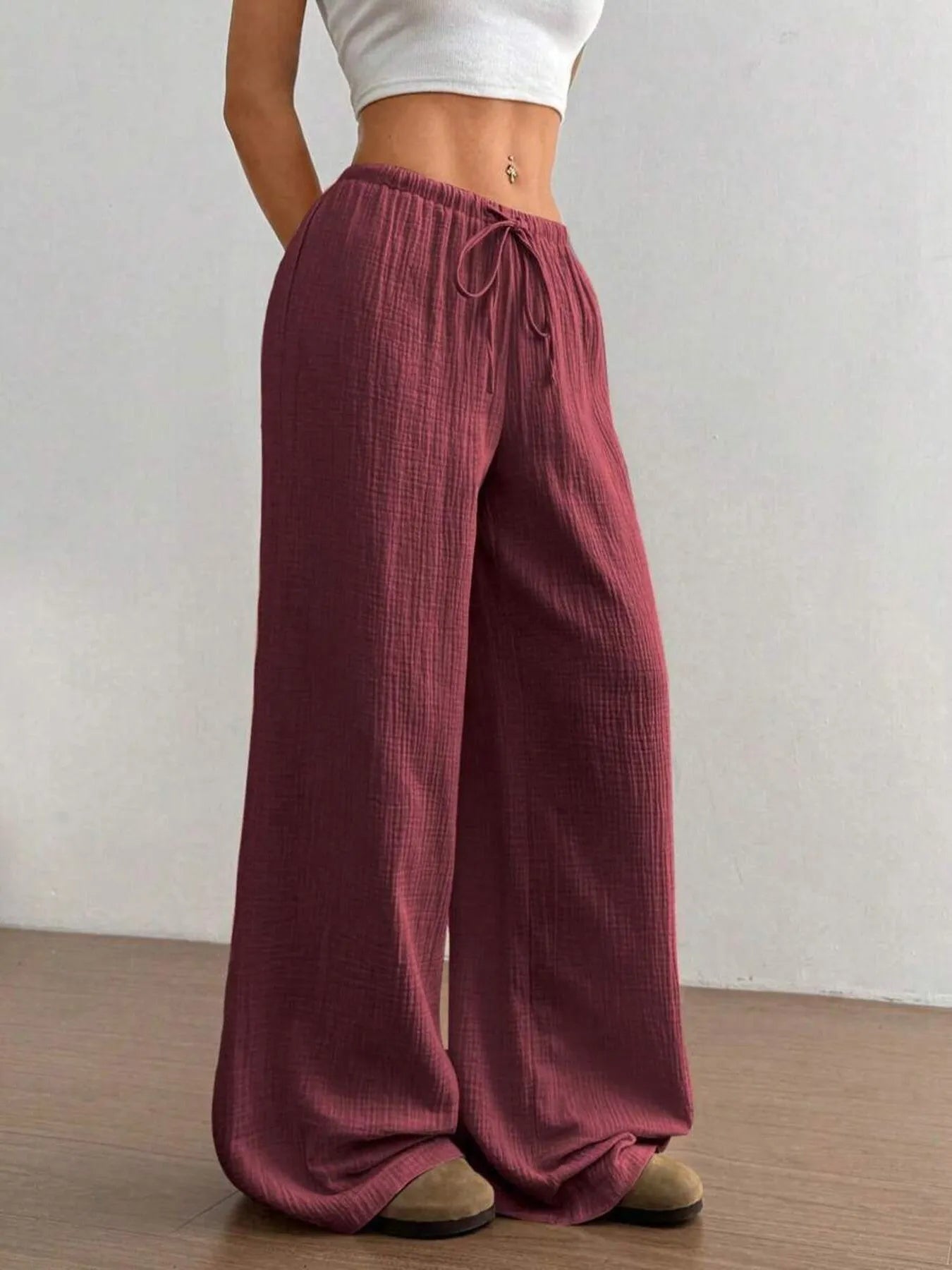 Maroon wide-leg pants worn by a person on a plain background