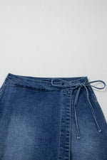 Blue denim skirt with a tie waist on a light gray background