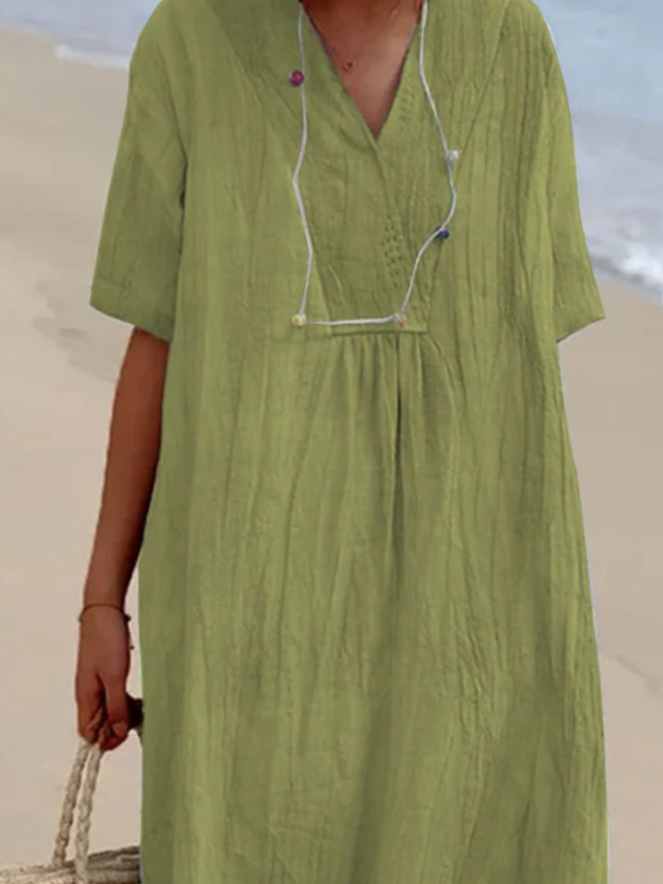 Green dress worn by a person on a beach