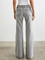 Person wearing light gray wide-leg jeans on a plain background