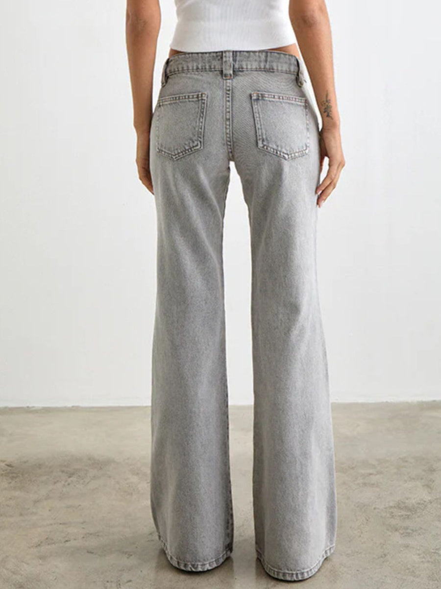 Person wearing light gray wide-leg jeans on a plain background