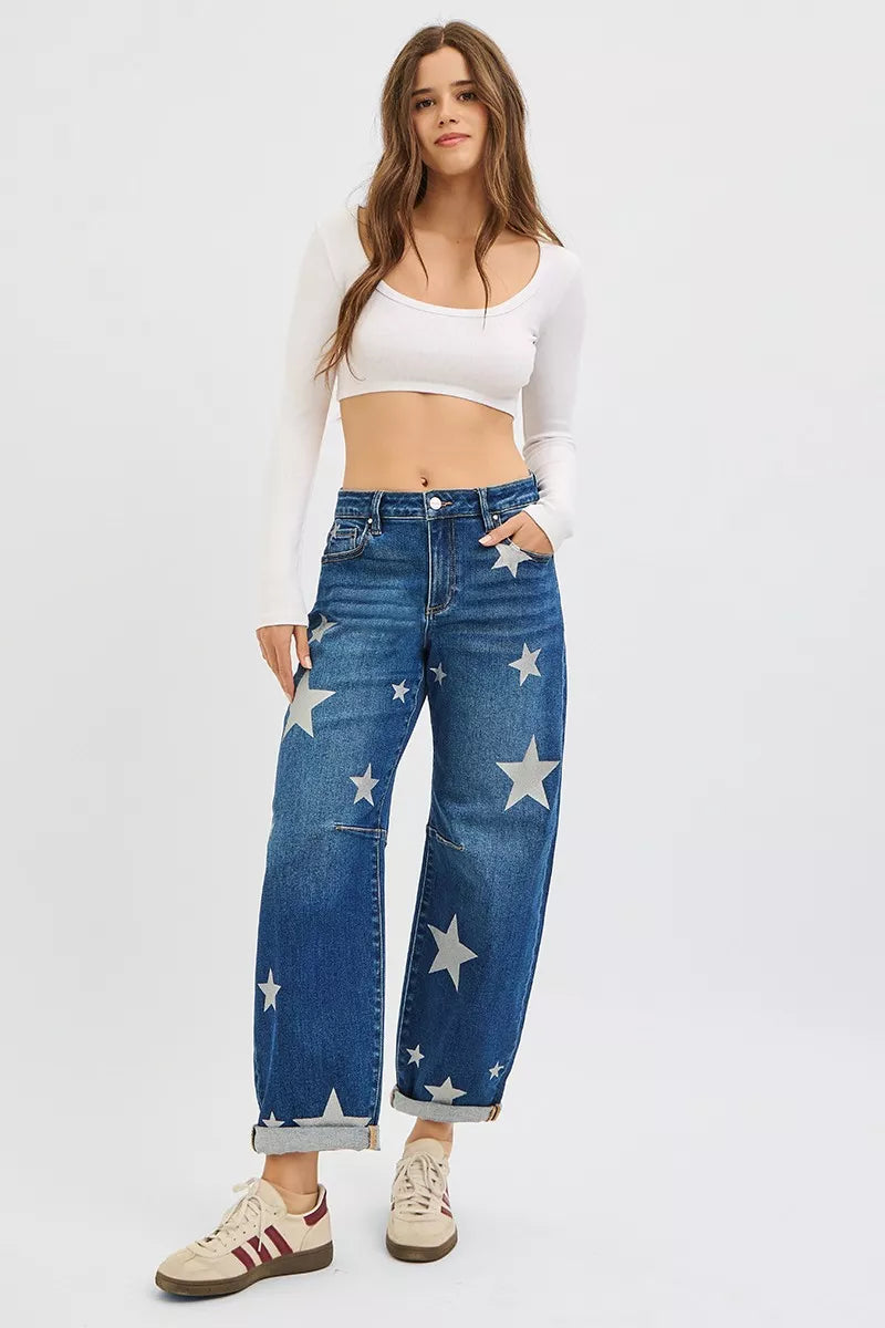Woman wearing blue jeans with star patterns on a white background