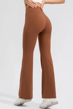 Brown flared pants worn by a person on a white background