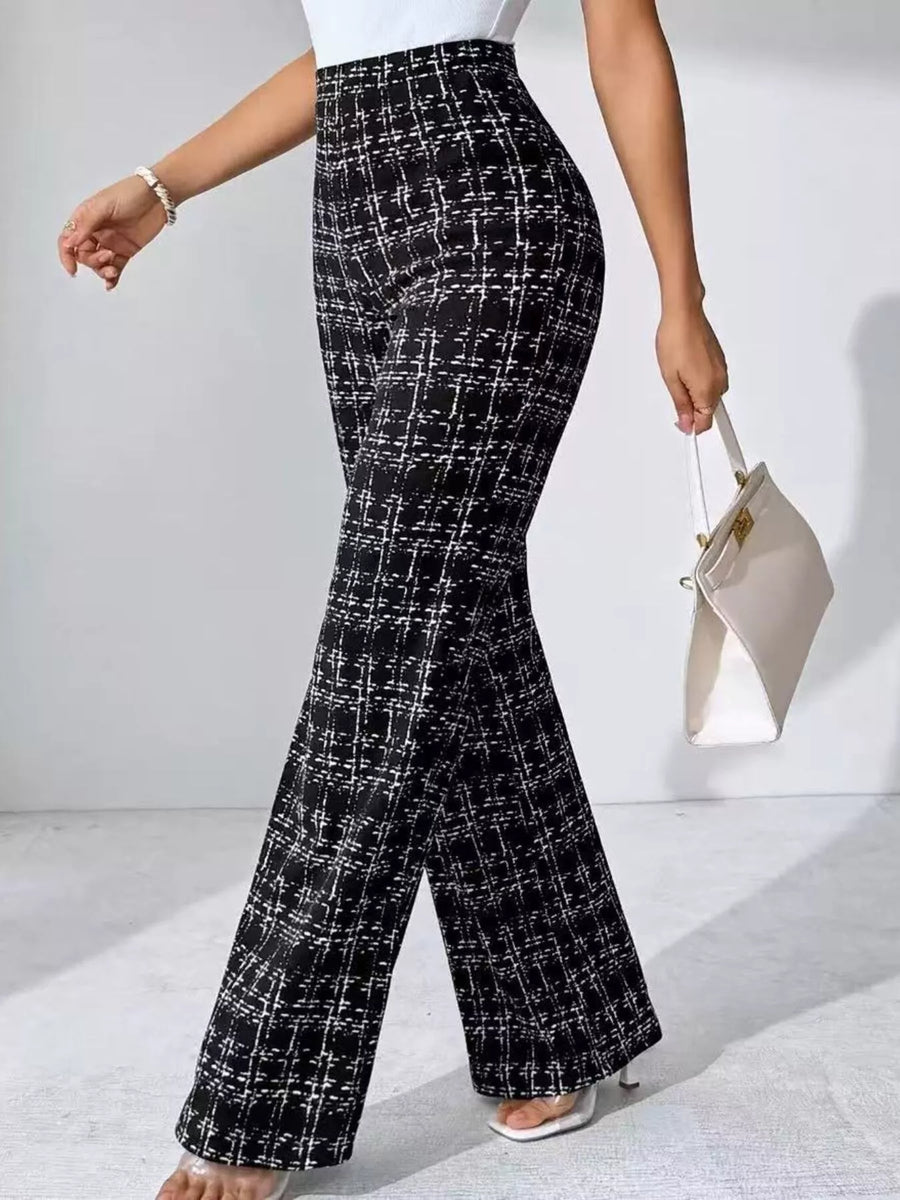 Person wearing black and white checkered pants on a light gray background