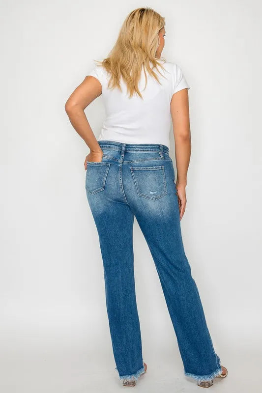 Woman wearing blue jeans and a white top on a plain background