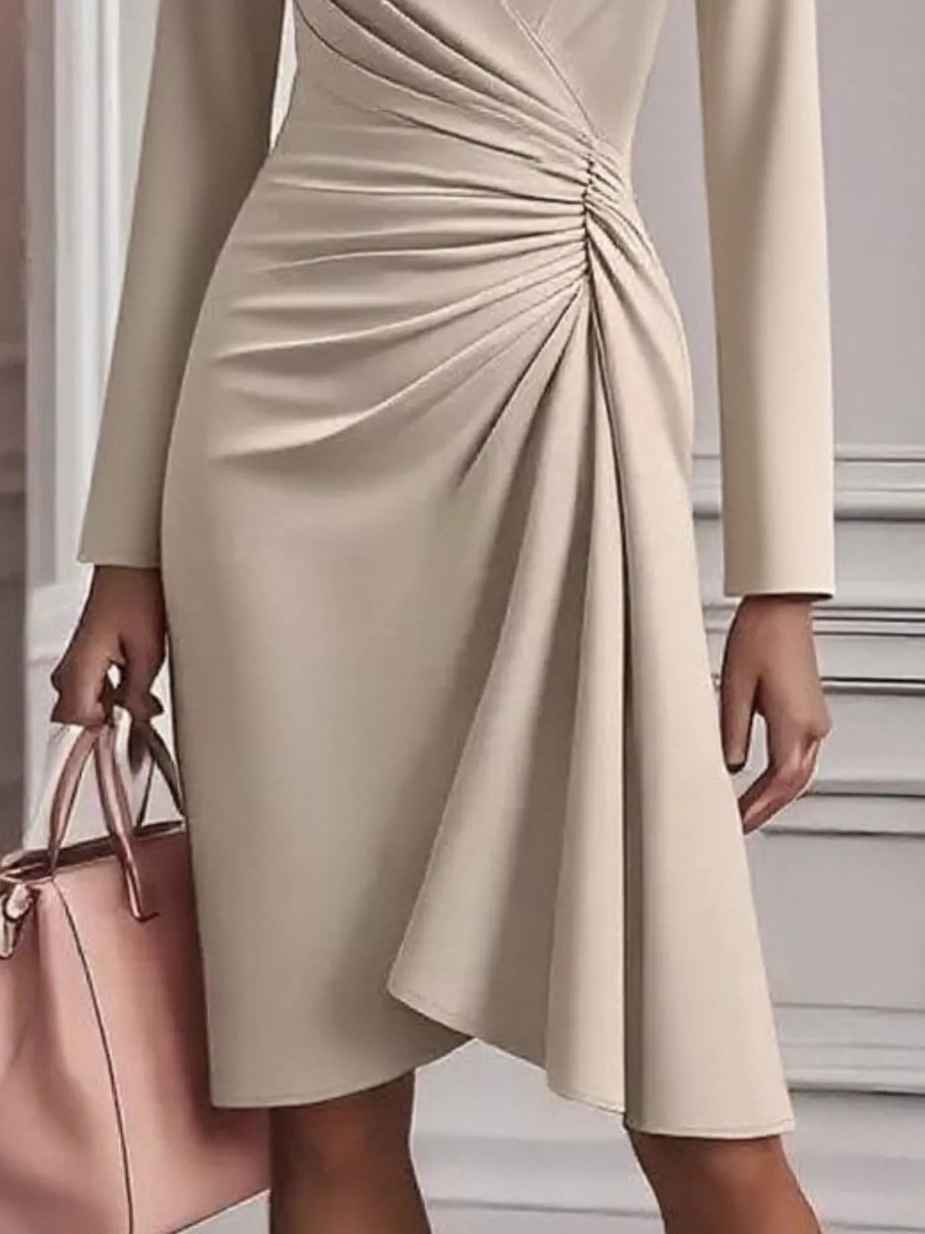Beige dress with a knot detail worn by a person, holding a pink handbag.