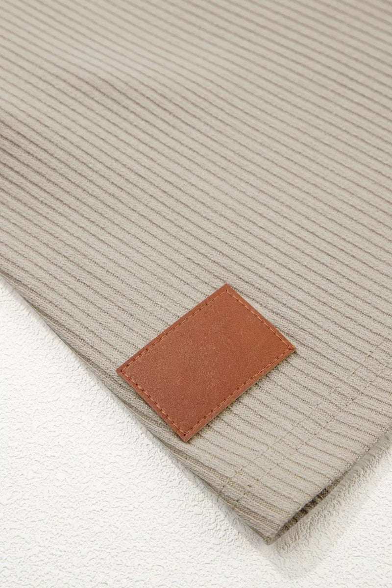 Close-up of a beige fabric with a brown leather label.